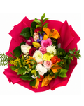 Colorful bouquet of flowers with a pink paper wrap on a white background