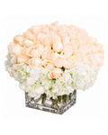 Hexagonal glass vase with peach and white flowers on a white background