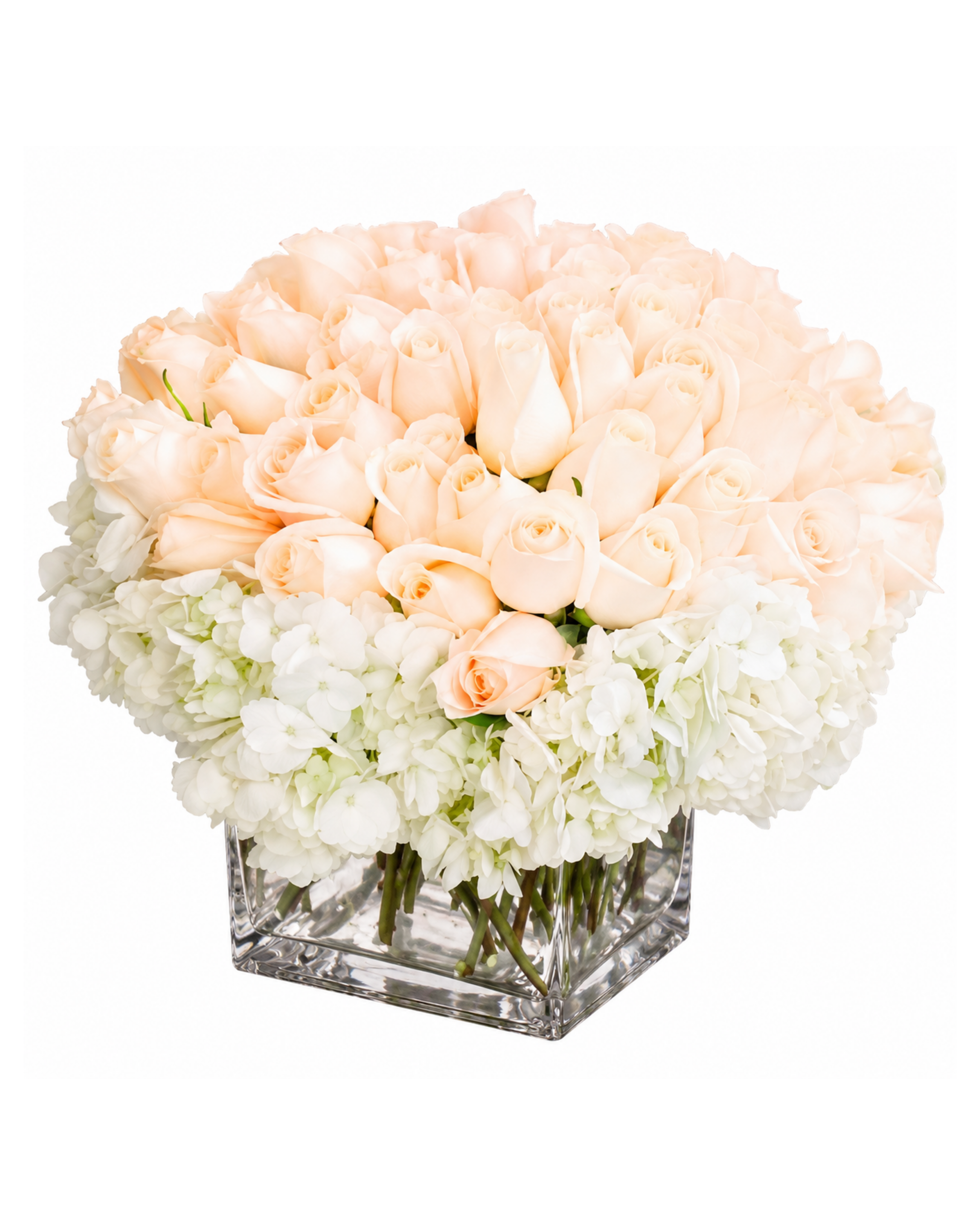 Hexagonal glass vase with peach and white flowers on a white background