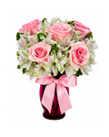 Bouquet of pink roses and green flowers in a red vase with a pink ribbon on a white background