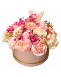 Decorative flower arrangement with pink and white flowers in a round container on a white background